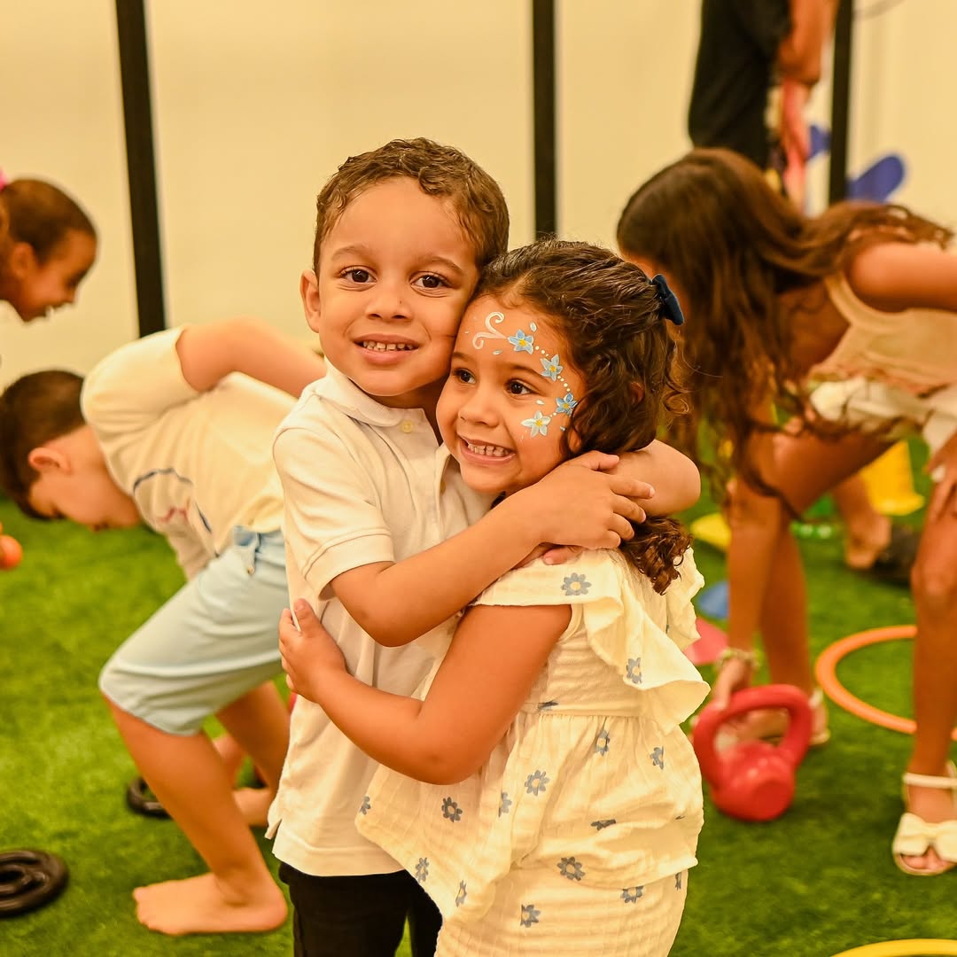 Educadora orientando crianças em exercícios divertidos na Gym Kids